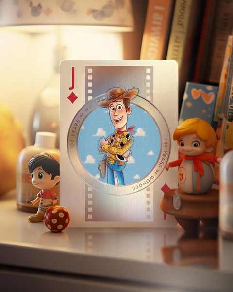 Kortų kolekcinė korta Jack (deimantas) su Woody iliustracija, sidabriniu rėmeliu ir mėlynu apskritimu, stalo artime