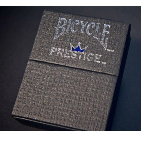 Bicycle Prestige kortų dėžutė juoda tekstūruota su sidabriniu logotipu ir mėlyna karūna, pasvirusiu kampu ir artimas planas