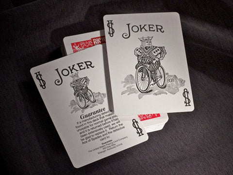 Bicycle žaidimo kortos – dvi juodai baltos Joker kortos ant raudonų nugarėlių, atidengtos viršuje ir šiek tiek pasuktos