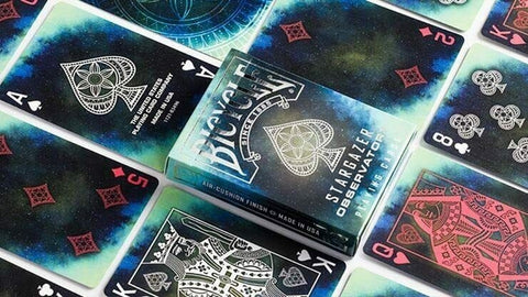 Bicycle Stargazer kortos su kosminiu mėlyno‑žalsvu dizainu, dėžutė centre ir paskleistos kortos kitokiu kampu