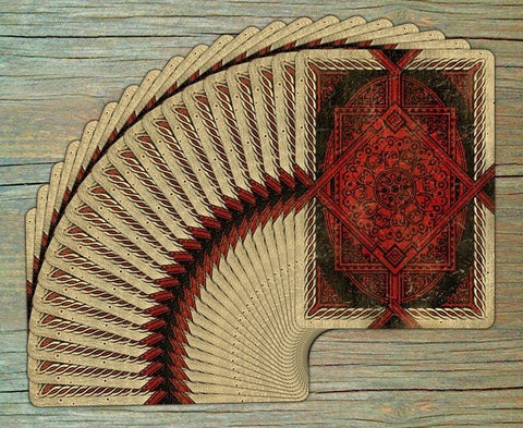 Kortos su raudonai ir smėlio spalvos ornamentuotomis nugarėlėmis, išdėstytos vėduokle, pabrėžiančios dizaino detales