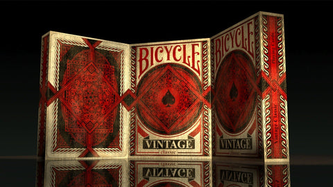 Bicycle vintage kortos su raudonu ir smėlio ornamentu, trijų dėžių stendas parodytas priekiniu kampu ant atspindinčios paviršiaus