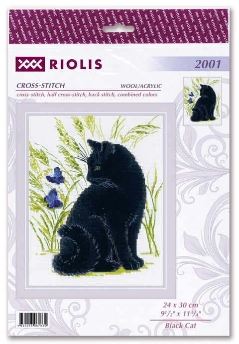 Siuvinėjimo rinkinys: juoda katė sėdi tarp žolių ir violetinių žiedų, komplekte vilnos/akrilo siūlai 24×30 cm