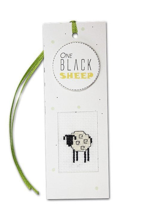 Knygos skirtukas One Black Sheep baltas su kryželiu – juoda avytė centre ir žalia satino juostelė