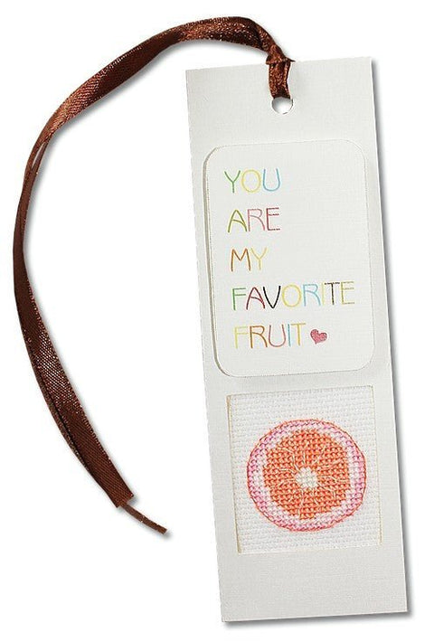 Knygų skirtukas baltas su rudu kaspinu, užrašu You are my favorite fruit ir siuvinėta greipfruto skiltele apačioje