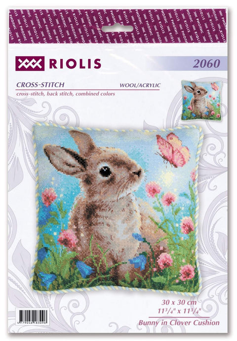 Kryželių pagalvėlė Riolis 30×30 cm su siuvinėtu triušiu, dobilais ir drugeliu ant šviesiai mėlyno fono