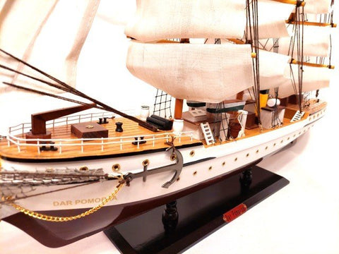 Laivo modelis Dar Pomorza — baltas ir rudas medinis, rodantis priekinės denio ir kalių detales ant stovo