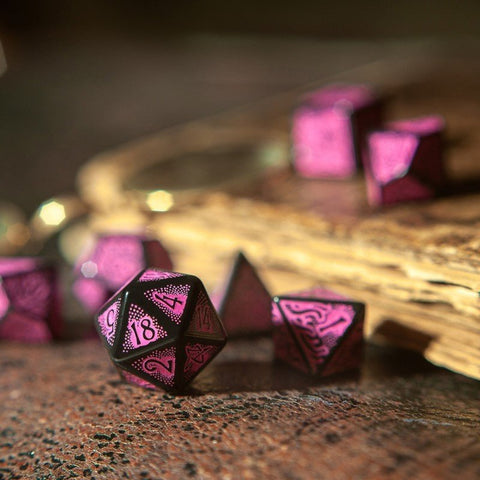 Poliedriniai žaidimo kauliukai rožinė–juoda metalinė versija, arti fokusas ant d20 su 18, kontekstą suteikia senovinė knyga heirloom fone