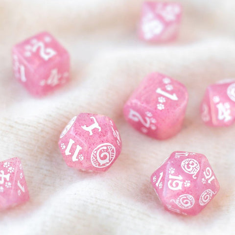 Kauliukai rožiniai blizgantys RPG komplektui, arti sufokusuotas rinkinys su baltais skaitmenimis ant megzto fono