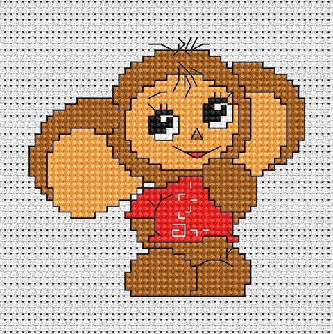 Siuvinėjimo rinkinys Cheburashka — rudas personažas su raudona palaidine ant baltos tinklelio drobės, artimas planas ir matomi kryželių dygsniai