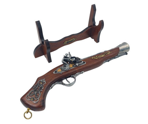 Senovinė flintlock pistoletė tamsaus medžio su aukso ir sidabro ornamentais, pateikta ant medinio stovelio