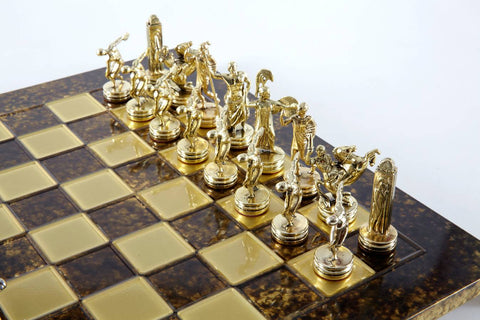 Šachmatų rinkinys su aukso spalvos klasikinėmis figūromis ant tamsiai rudos ir aukso languotos lako lentos, dešinės pusės artimas planas