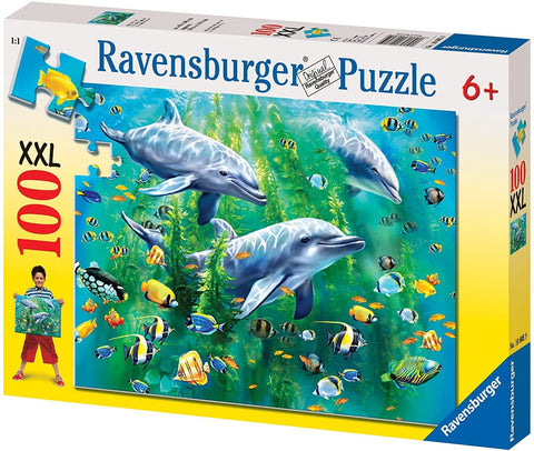 Dėlionė Ravensburger 100 XXL su jūros gyvūnų motyvu: ryški trijų delfinų scena po vandeniu, dėžutės priekinė iliustracija