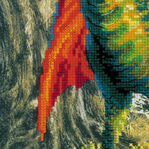 Siuvinėjimo rinkinys — arti užfiksuoti tankūs kryželiai ir sodrios raudonų, žalių bei mėlynų siūlų perėjimai ant audinio