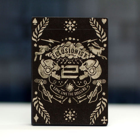 kortų dėžutė Ellusionist, juoda su kreminiu ornamentu ir logotipu priekyje, tiesinis kampo vaizdas akcentuoja dekorą
