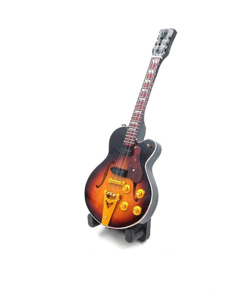 Elektrinė gitara sunburst apdaila su auksinėmis detalėmis ir keturiomis valdymo rankenėlėmis, trijų ketvirčių kampu ant stovo