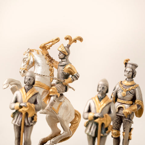 Šachmatų figūrėlė raitelis su sidabro ir aukso apdaila, arti kadro, parodo detalius šarvus, riestą žirgo pozą ir tekstūrą