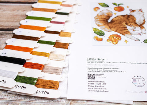 Kryželių rinkinys Letistitch su apie 20 įvairiaspalvių siūlų kortelių ir Aida schema „Ginger“ su oranžine kate, arti kad matytųsi spalvų paletė