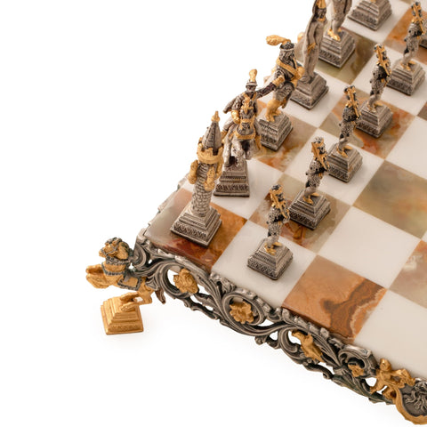 Šachmatai iš marmuro ir metalo su auksuotais ir sidabruotais figūrų akcentais, rodant artimą krašto ir kampo ornamentų detalę