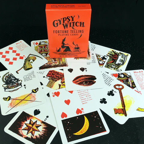 Pranašystės kortos Gypsy Witch oranžinėje pakuotėje, išskleistos kortos su mėnuliu, raktu, akimi ir detaliais simboliais