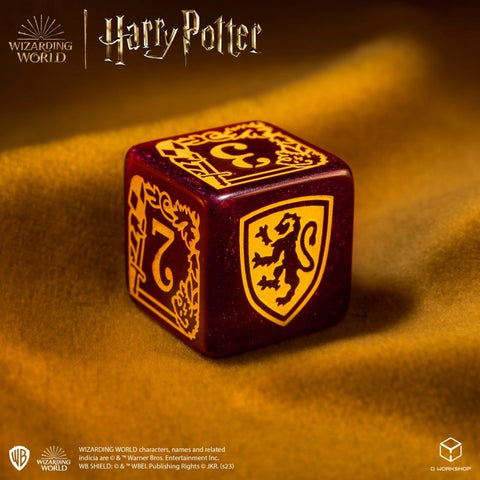 Kauliukas Gryffindor, tamsiai raudonas su auksiniu liūto skydeliu ir skaičiumi 7, makro kampu ant geltono aksomo