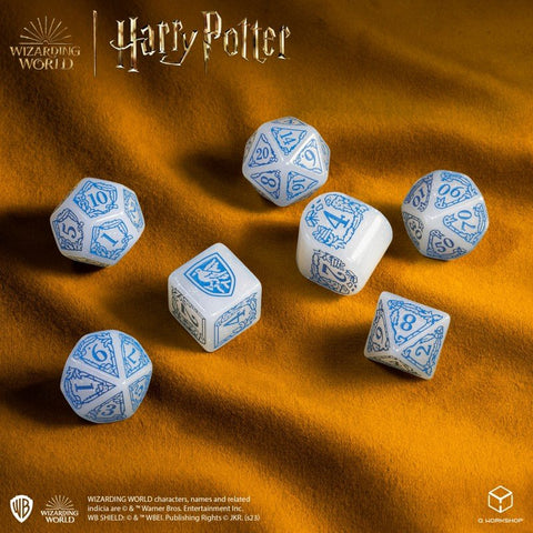 Kauliukų rinkinys Harry Potter, baltos blizgios poliedrinės kauliukai su mėlynais skaičiais, 7 vnt., pateikti ant geltono aksomo