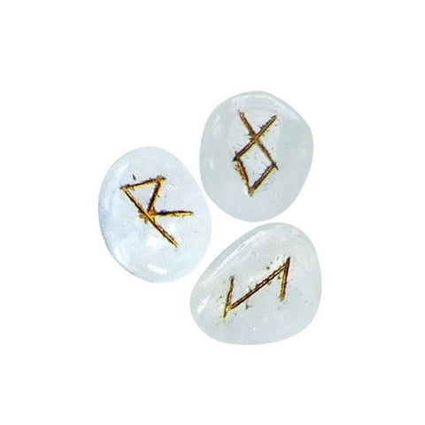 Kvarcinės runos, trijų permatomų baltų akmenų rinkinys su auksuotais įspaustais ženklais, artimas planas