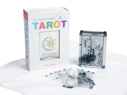 Skaidrus tarot rinkinys Emily Carding: baltas dėklas su spalvotu logotipu, plastikinė dėžutė ir išskleistos permatomos kortos