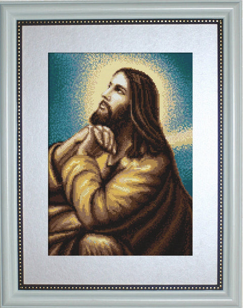 Siuvinys kryželiu: Kristaus portretas rudos ir auksinės tonų paletėje su melsvu fonu, įrėmintas baltu dekoratyviniu rėmu, 40×50 cm