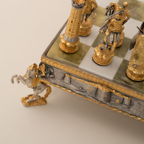 Šachmatai – art deco stiliaus auksuotoje ir sidabruotoje detalėje, užfiksuota kampinė žirgo koja ir kvadratų kraštas