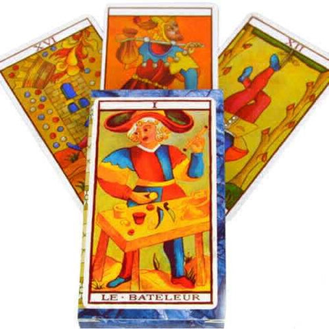 Tarot kortos Marseille stiliaus, priekyje „Le Bateleur“ korta ryškiais oranžiniais ir mėlynais atspalviais, trys atverstos kortos fone