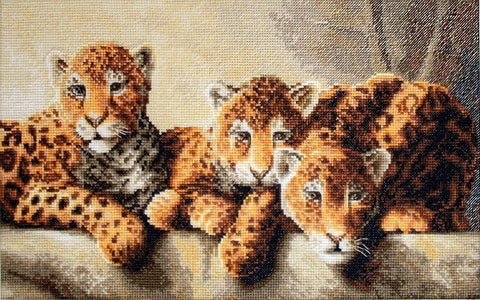 Kryželių rinkinys su trimis rudos spalvos leopardo jaunikliais, horizontali 40×60 cm kompozicija, pabrėžianti detalią siūlų tekstūrą ir centro motyvą
