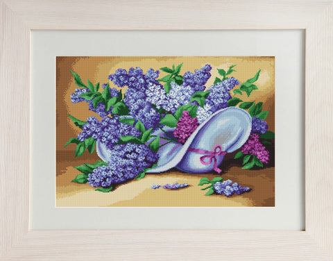 Siuvinėtas paveikslas alyvų puokšte ant kepurės, violetinės ir žalios spalvos siūlai, baltas rėmas, artimas kampas, matomas siūlių reljefas