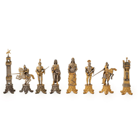 Šachmatai aukso ir sidabro tonų, dekoratyvios viduramžių figūrėlės išdėstytos eilėje, matomas visas rinkinys