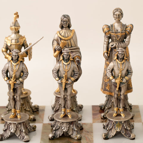 Šachmatų figūrėlės sidabrinės su auksinėmis detalėmis, artimas priekinis kadras: trys pėstininkai prieš karališkas figūras