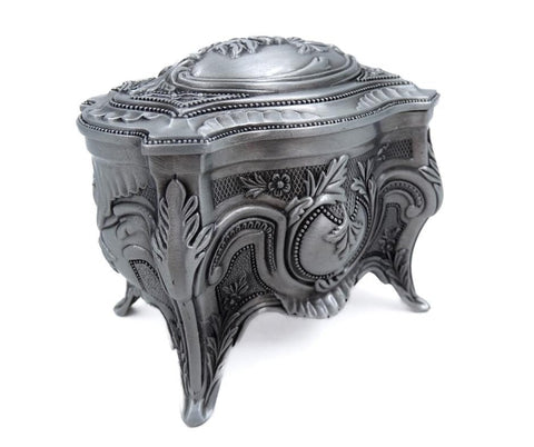 Papuošalų dėžutė baroko stiliaus su antikiniu sidabro tonu, išraižytais augaliniais motyvais ir trijų kojelių priekinio kampo vaizdu.