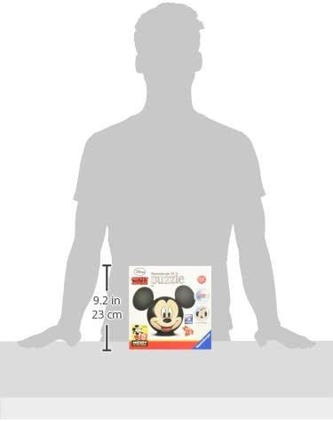 Mickey dėlionė dėžutė (apie 23 cm aukščio) rodoma ant stalo prie žmogaus silueto, pabrėžiant dydį ir pakuotės dizainą