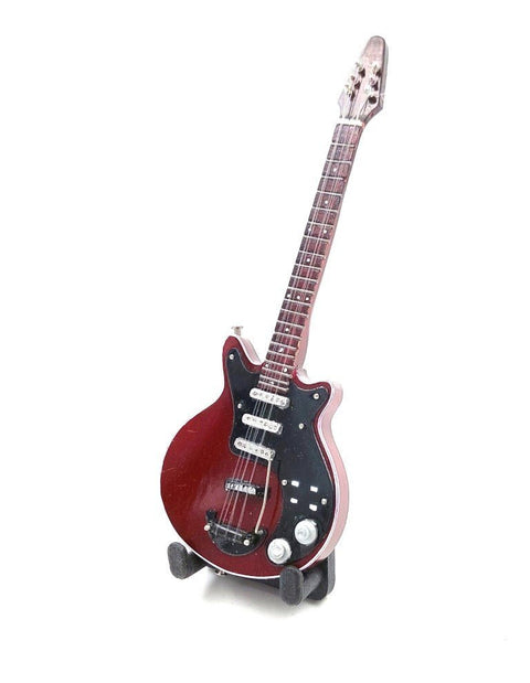 Elektrinė gitara bordo spalvos su juodu pickgardu ir trimis pikapais, stovinti ant stovelio priekinio kampo rodinyje