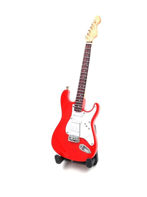 elektrinė gitara ryškiai raudona Strat stiliaus korpusas su baltu pickguardu, tamsiu fingerboardu ir stovu