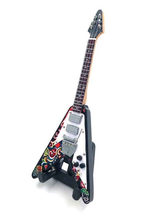 Elektrinė gitara V formos, balta pickguard ir spalvotas gėlių raštas, trys chromuoti pikapai, pasviręs priekinis kampas