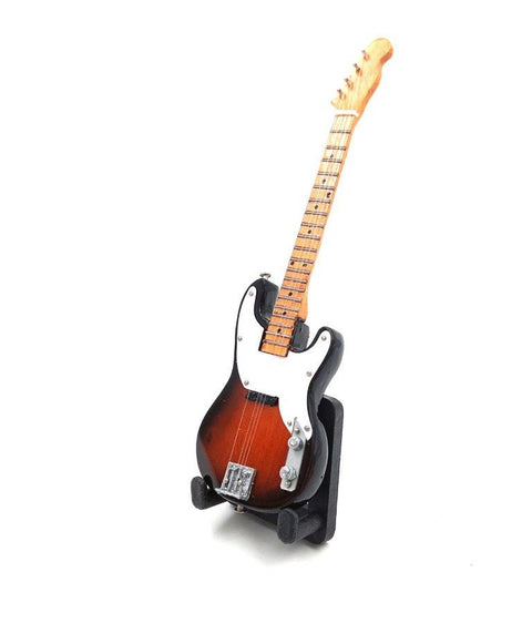 Elektrinė gitara sunburst apdaila su klevo kaklu ir balta plokštele, pasvirusi ant stovo parodyta iš priekio–šono