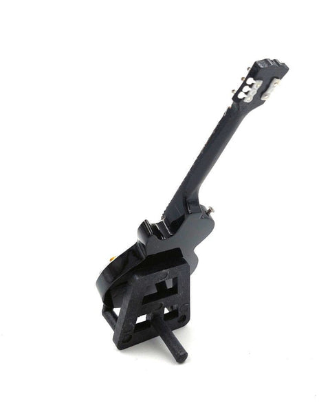 Mini elektrinė gitara juoda blizgi ant mažo trikampio stovelio, nugarinis kampinis vaizdas, skirta stalo ekspozicijai