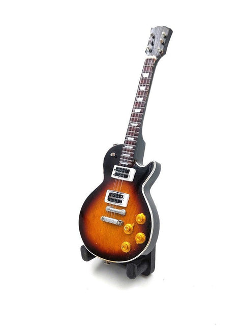 Elektrinė gitara sunburst spalvos, kompaktiško vienkorpio dizaino su chromuotais pikapais ir auksinėmis rankenėlėmis, rodoma kampu ant stovo