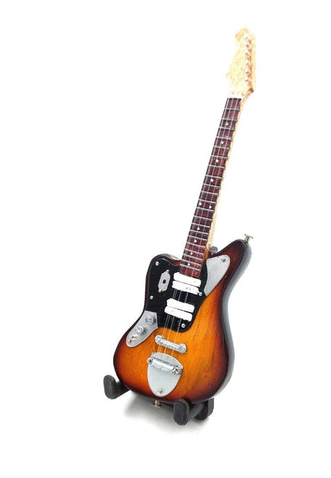 Elektrinė gitara sunburst apdaila, trys pikapai ir chromuotos dalys, rodoma pasvirusiu kampu ant mažo stovo