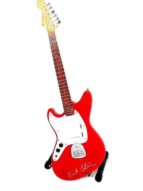 Elektrinė gitara raudonu korpusu ir baltu skydeliu, mediniu kakleliu, trijų ketvirčių kampu ant stovo