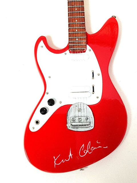 Elektrinė gitara raudonu blizgiu korpusu su balta apsaugine plokštele, rožinio riešuto kakleliu ir autografu, arti korpuso ir tiltuko kampo