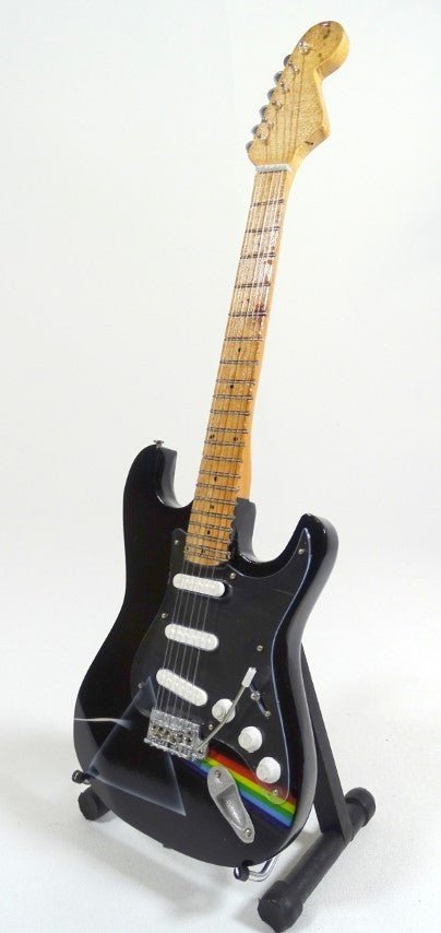Elektrinė gitara juoda su klevo kaklu ir vaivorykštės prizmės lipduku, stovinti ant stovelio, priekinė perspektyva skirta pardavimo produkto puslapiui