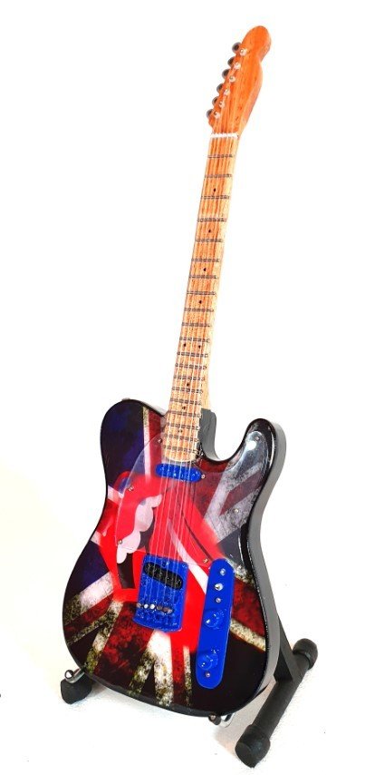 elektrinė gitara su Union Jack piešiniu ir mėlynais pikapais, šviesiu klevo kaklu, parodyta ant stovo kampu