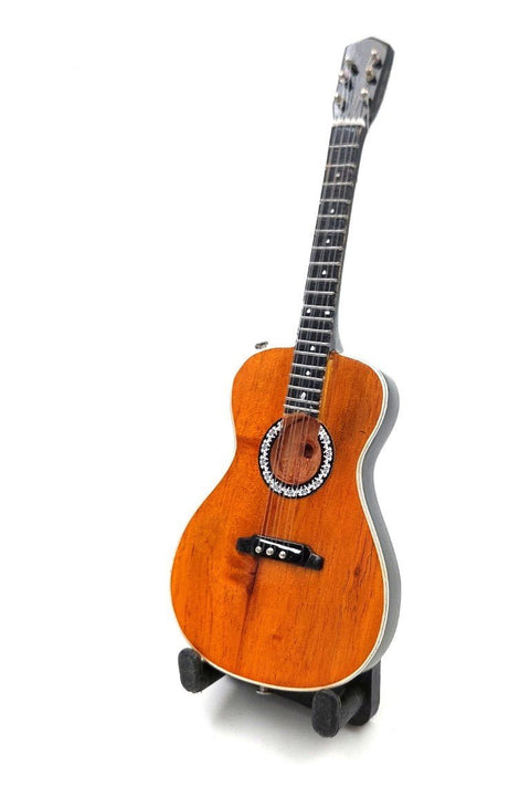 Akustinė gitara parlor dydžio šviesaus medžio apdaila su juoda tiltelio dalimi, dekoratyvia rožete ir stovelyje stovinti