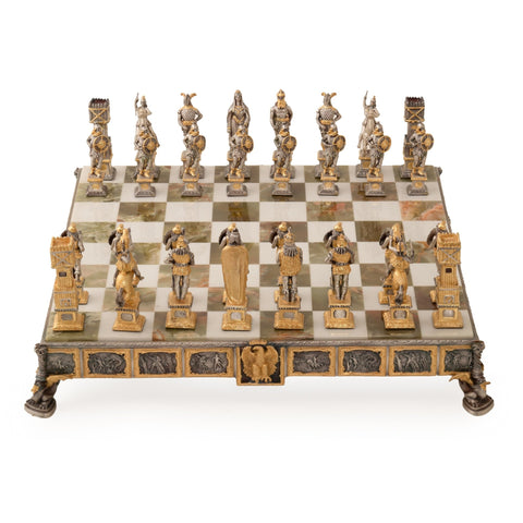 Šachmatai ant aukštos marmuro lentos su aukso ir sidabro metalinėmis figūromis, priekiniu kampu ir reljefine apdaila